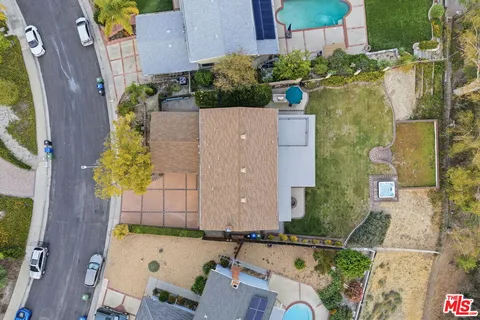 aerial view of a house with swimming pool and large trees