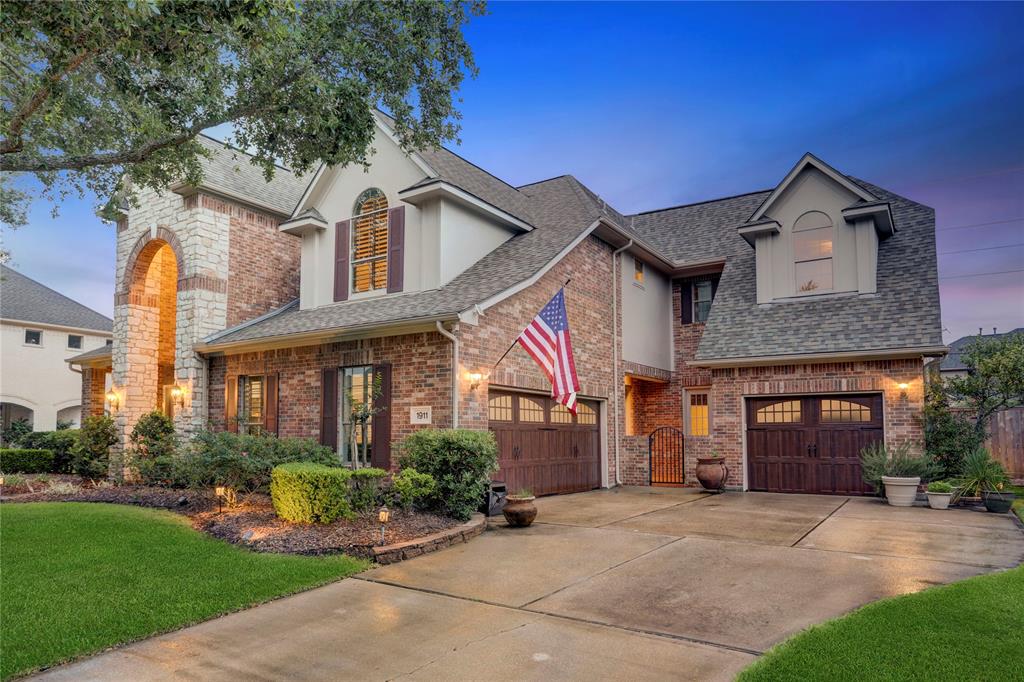 THIS BEAUTIFUL HOME GREETS YOU WITH A LUSH FRONT LAWN, SPRAWLING TREES, AND A CLASSIC BRICK AND STONE EXTERIOR.