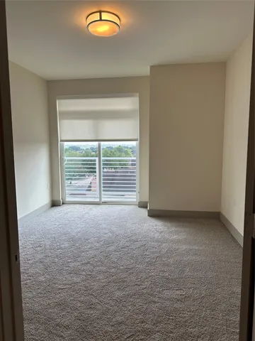 an empty room with wooden floor and window