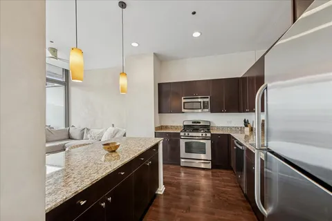 a kitchen with stainless steel appliances granite countertop sink stove and refrigerator