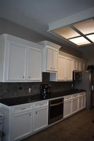 a kitchen with stainless steel appliances granite countertop white cabinets sink and stove