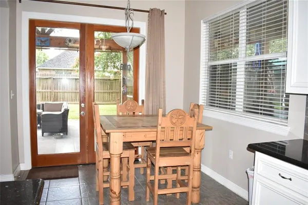a dining room with furniture and large windows