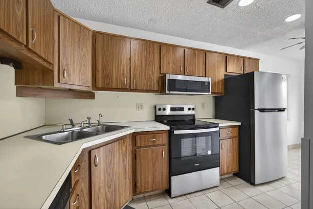 a view of a big room with wooden floor and windows