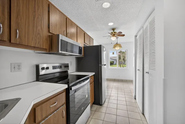 an empty room with a window and a ceiling fan