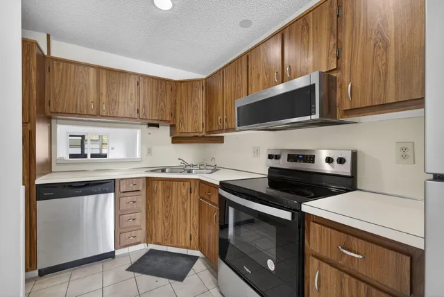 a kitchen with granite countertop a refrigerator and a sink