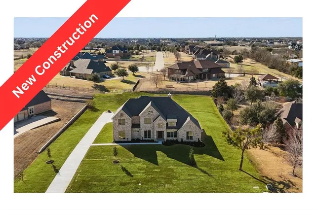 a front view of house with yard and trees in the background