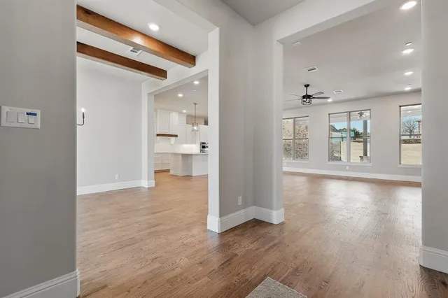 a kitchen with stainless steel appliances kitchen island granite countertop a dining table chairs and white cabinets