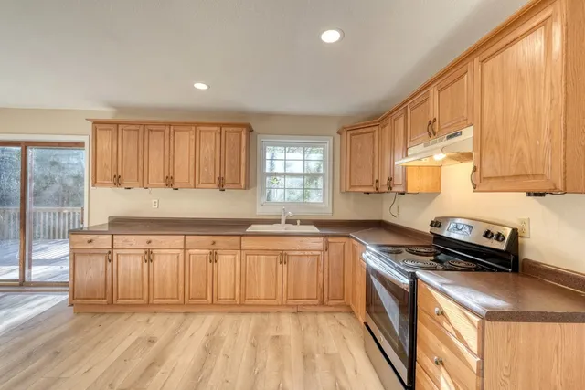a kitchen with stainless steel appliances granite countertop a stove a sink and a refrigerator