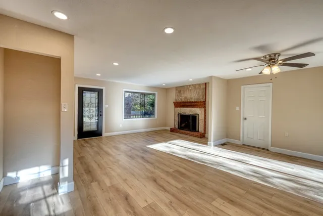 a view of an empty room with a fireplace and a window