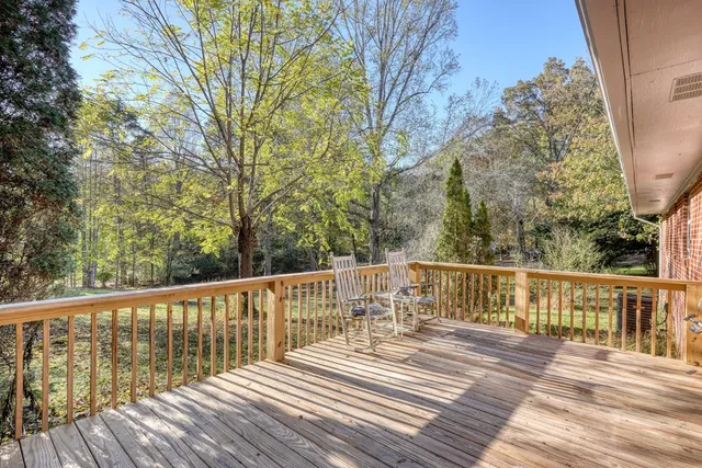 a view of balcony with wooden floor and fence