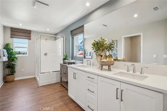 a bathroom with a double vanity sink mirror and shower