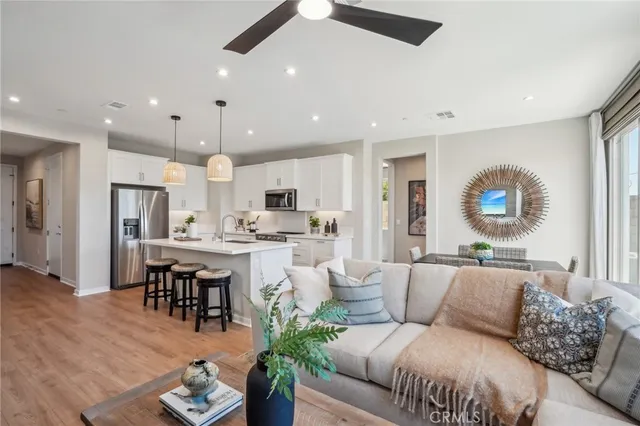 a living room with furniture kitchen view and a large window