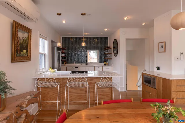 a room with stainless steel appliances kitchen island granite countertop a sink and cabinets