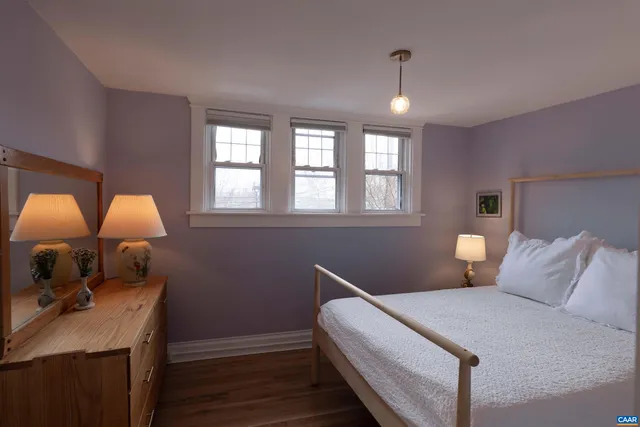 a bedroom with a bed window and dresser