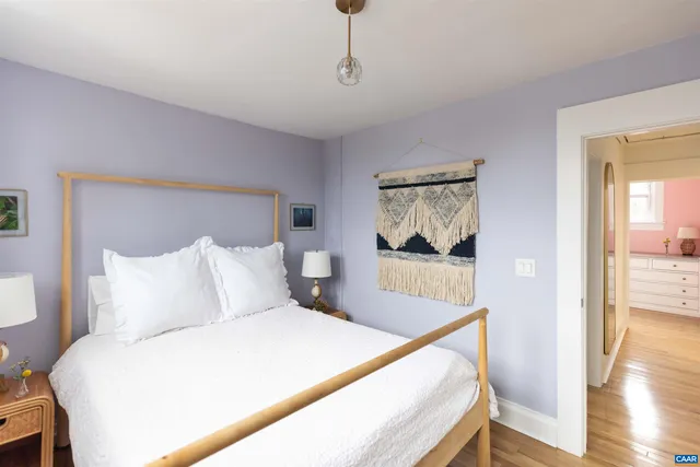 a bedroom with a large bed and wooden floor