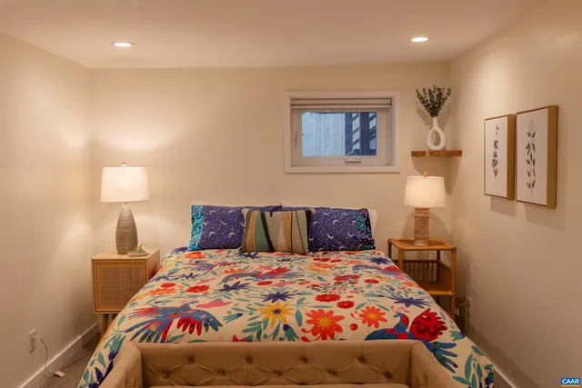 a bedroom with a bed and a lamp on dresser