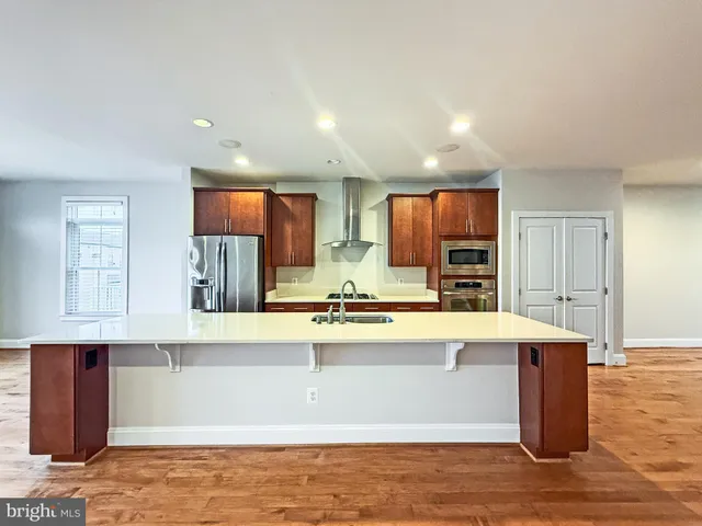 a large kitchen with kitchen island a sink stainless steel appliances and cabinets