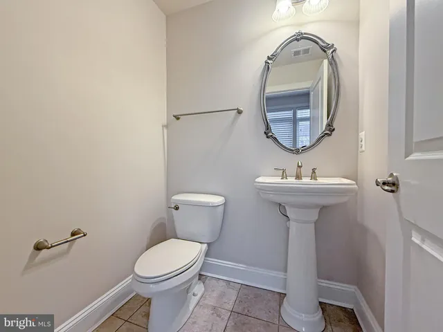 a bathroom with a sink toilet and a mirror
