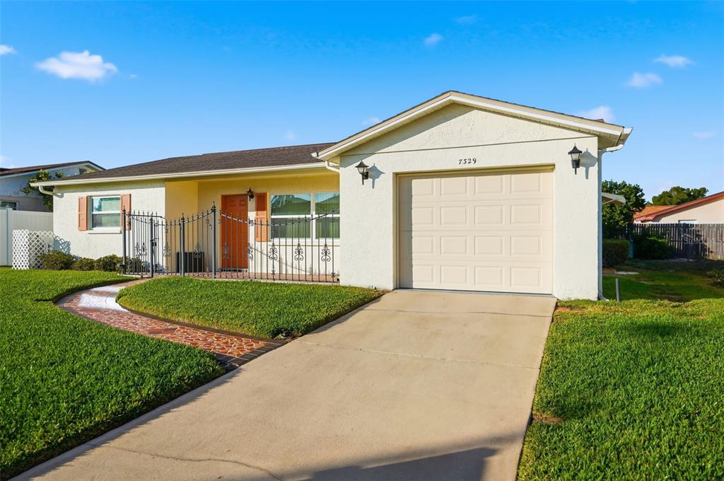 7329 Cay Drive Port Richey, FL 34668 - Photo 2 of 38 a front view of a house with garden