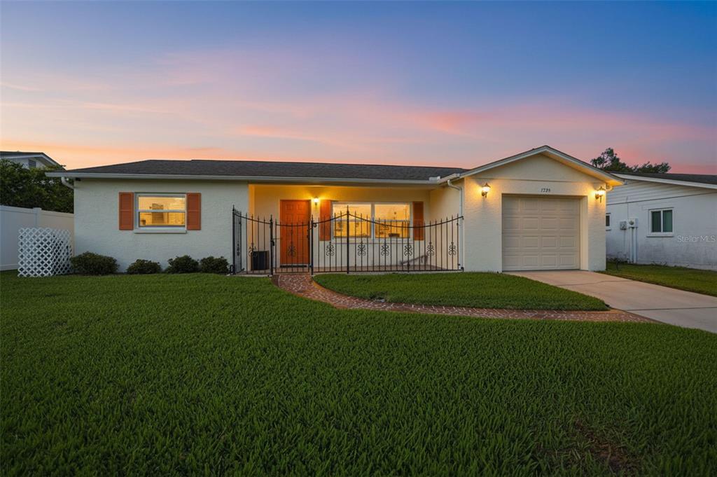 7329 Cay Drive Port Richey, FL 34668 - Photo 38 of 38 a front view of a house with a garden and yard