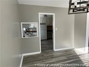 a view of a hallway with wooden floor and closet