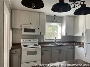 a kitchen with a sink a stove and cabinets
