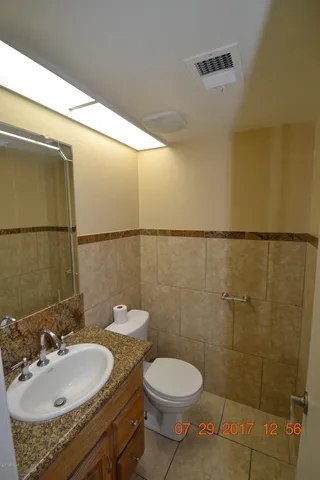 a bathroom with a granite countertop sink toilet and a mirror
