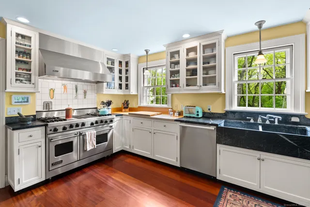 a kitchen with stainless steel appliances a stove a sink and a large window