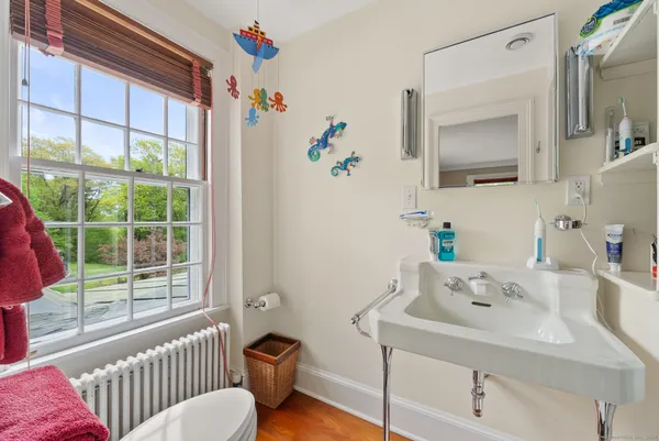 a bathroom with a sink mirror and a window