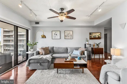 a living room with furniture ceiling fan and a rug