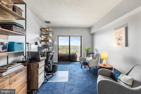 a living room with furniture floor to ceiling window and a flat screen tv