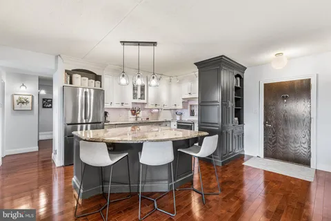 a kitchen with stainless steel appliances kitchen island granite countertop a dining table chairs and granite counter tops
