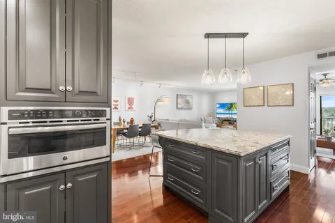 a kitchen with a stove cabinets and wooden floor
