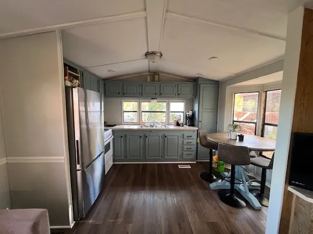 a kitchen with a refrigerator and wooden floor