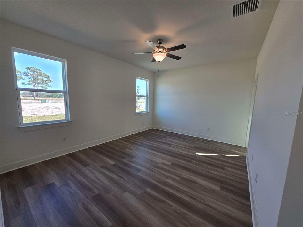 3827 Daybreak Run Loop Spring Hill, FL 34609 - Photo 11 of 14 a view of an empty room with wooden floor and a window