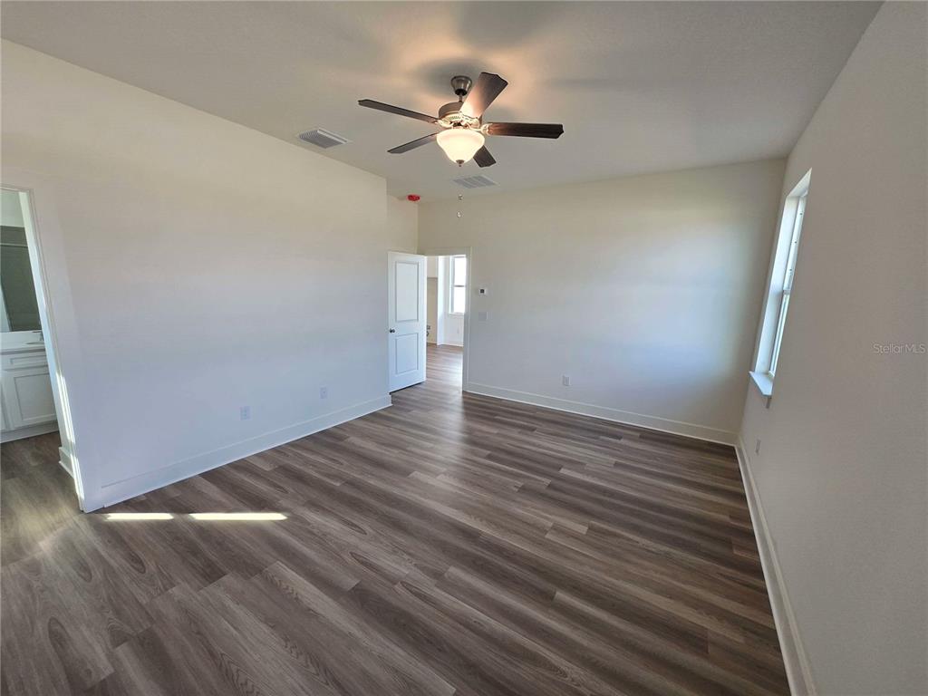 3827 Daybreak Run Loop Spring Hill, FL 34609 - Photo 7 of 14 wooden floor in an empty room with a window