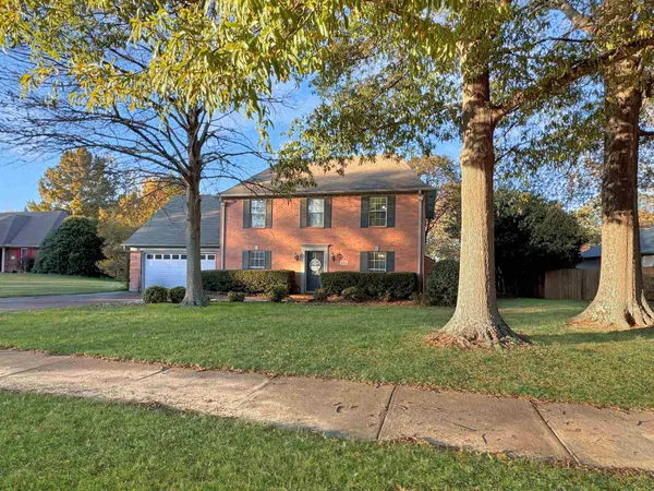 a front view of house with yard and green space