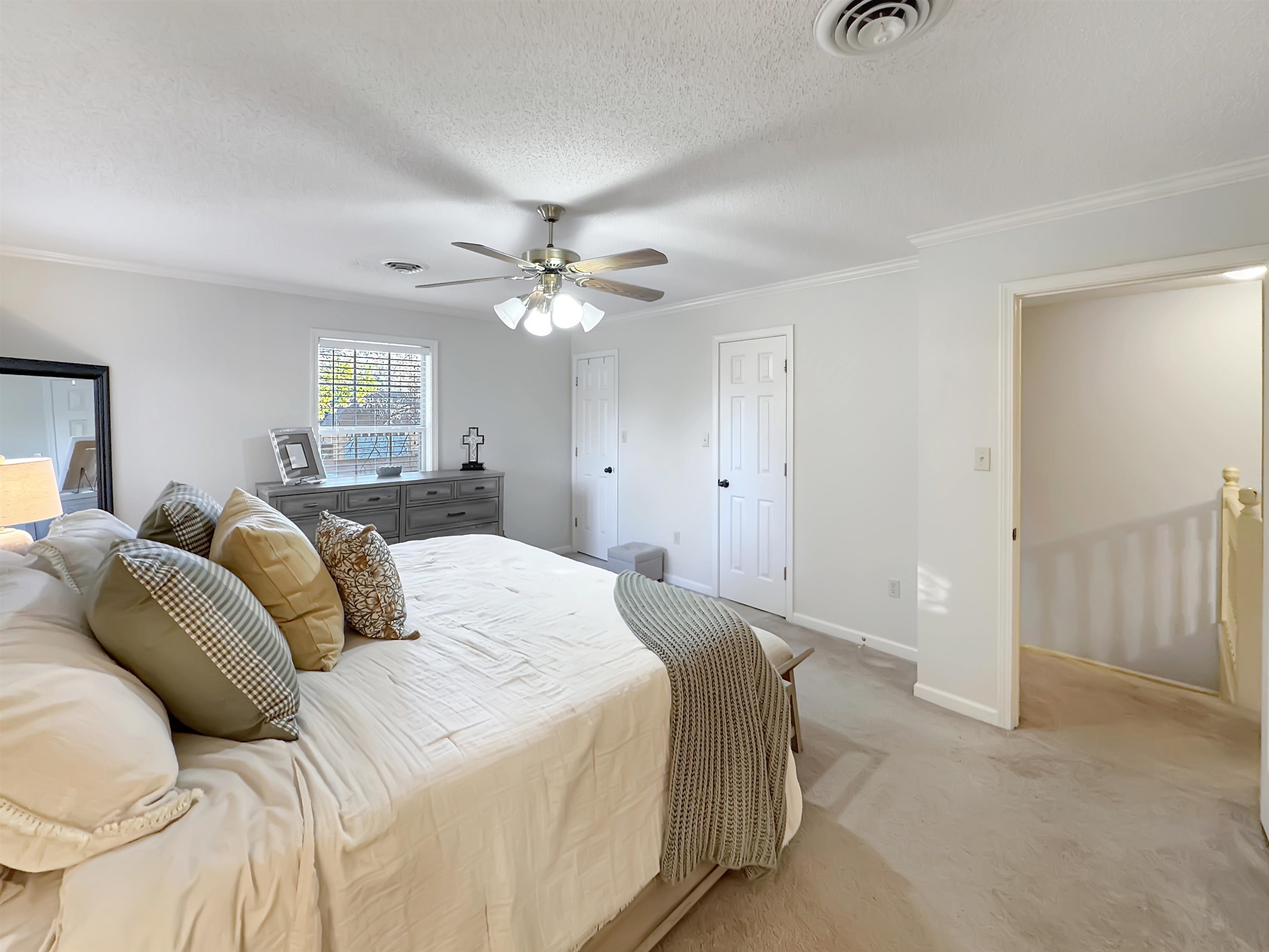 340 Scarlett's Way Collierville, TN 38017 - Photo 21 of 40 Bedroom featuring ornamental molding, multiple closets, a textured ceiling, carpet flooring, and a ceiling fan
