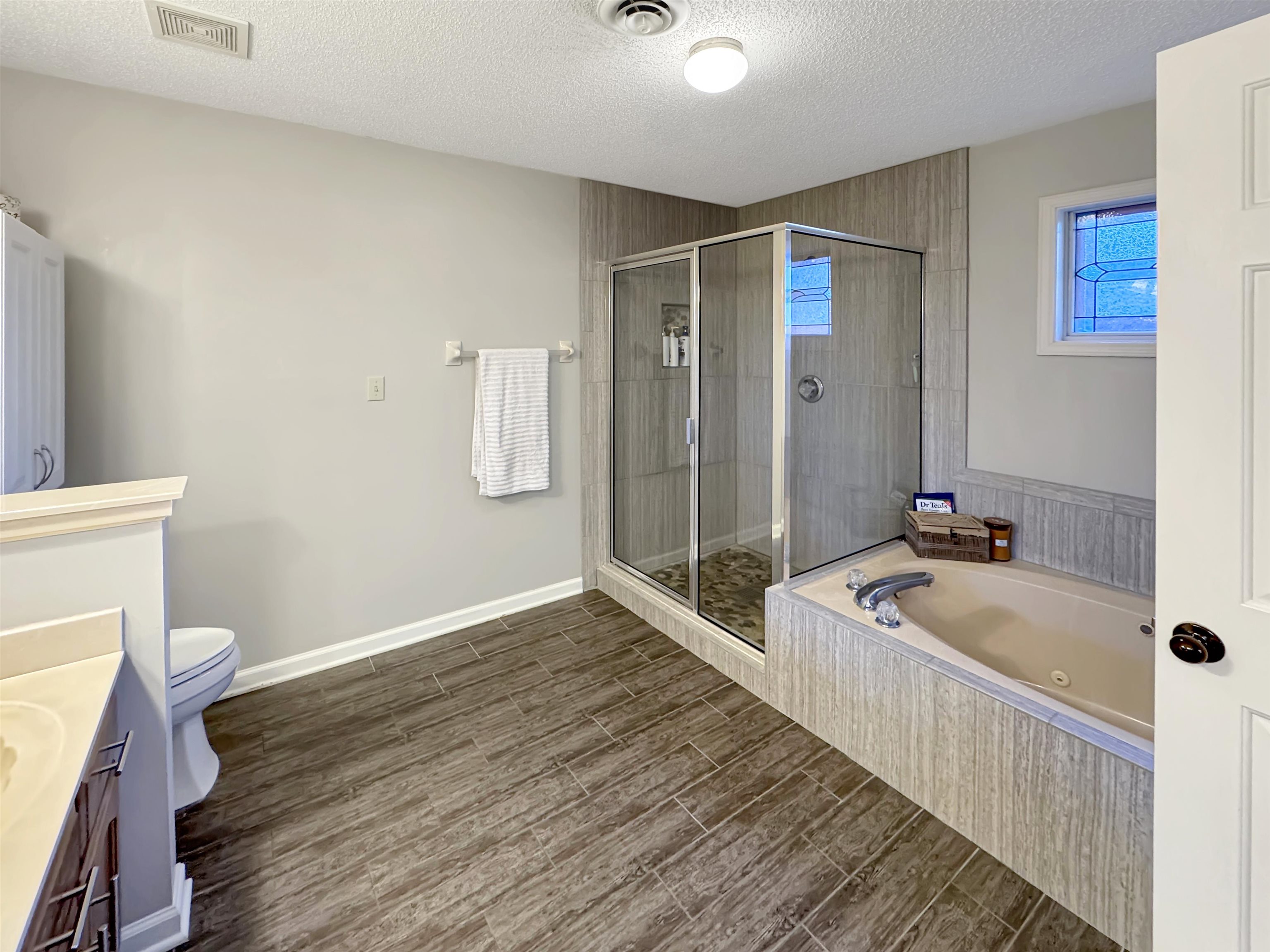 340 Scarlett's Way Collierville, TN 38017 - Photo 25 of 40 Bathroom with vanity, wood tiled floors, a tub with jets, a stall shower, and a textured ceiling