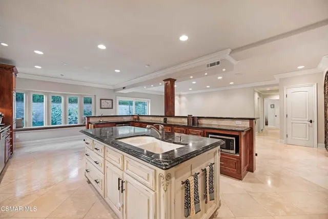 a spacious bathroom with a granite countertop sink a large mirror and cabinets