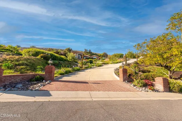 a view of a yard with an ocean and house in the background