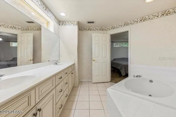 a spacious bathroom with a tub sink and a mirror