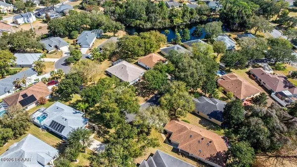 an aerial view of residential houses with outdoor space and trees