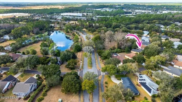 an aerial view of residential houses with outdoor space and trees