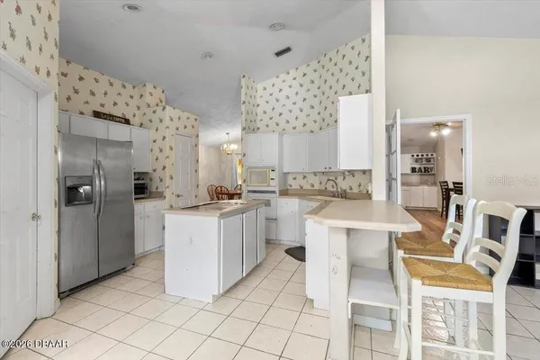 a kitchen with cabinets and chairs
