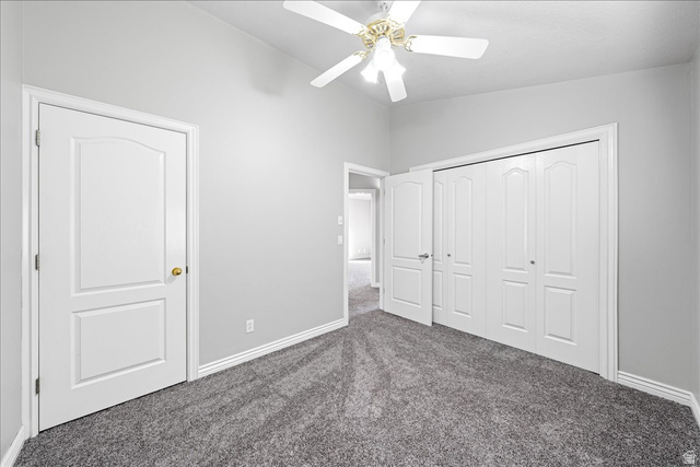 7 Reflection Way St. George, UT 84770 - Photo 39 of 54 Unfurnished bedroom with dark carpet, a ceiling fan, vaulted ceiling, and a closet