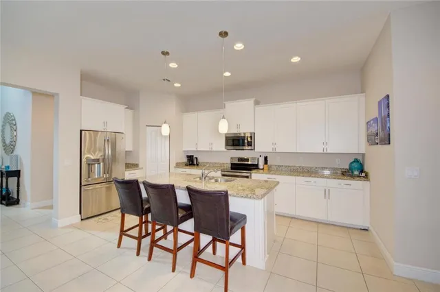 a kitchen with granite countertop white cabinets sink and stainless steel appliances