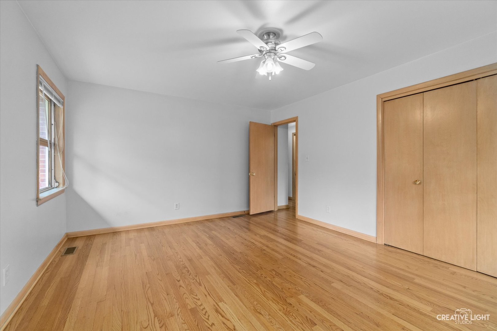 1402 Meadows Road Geneva, IL 60134 - Photo 22 of 30 a view of an empty room with wooden floor and a chandelier fan