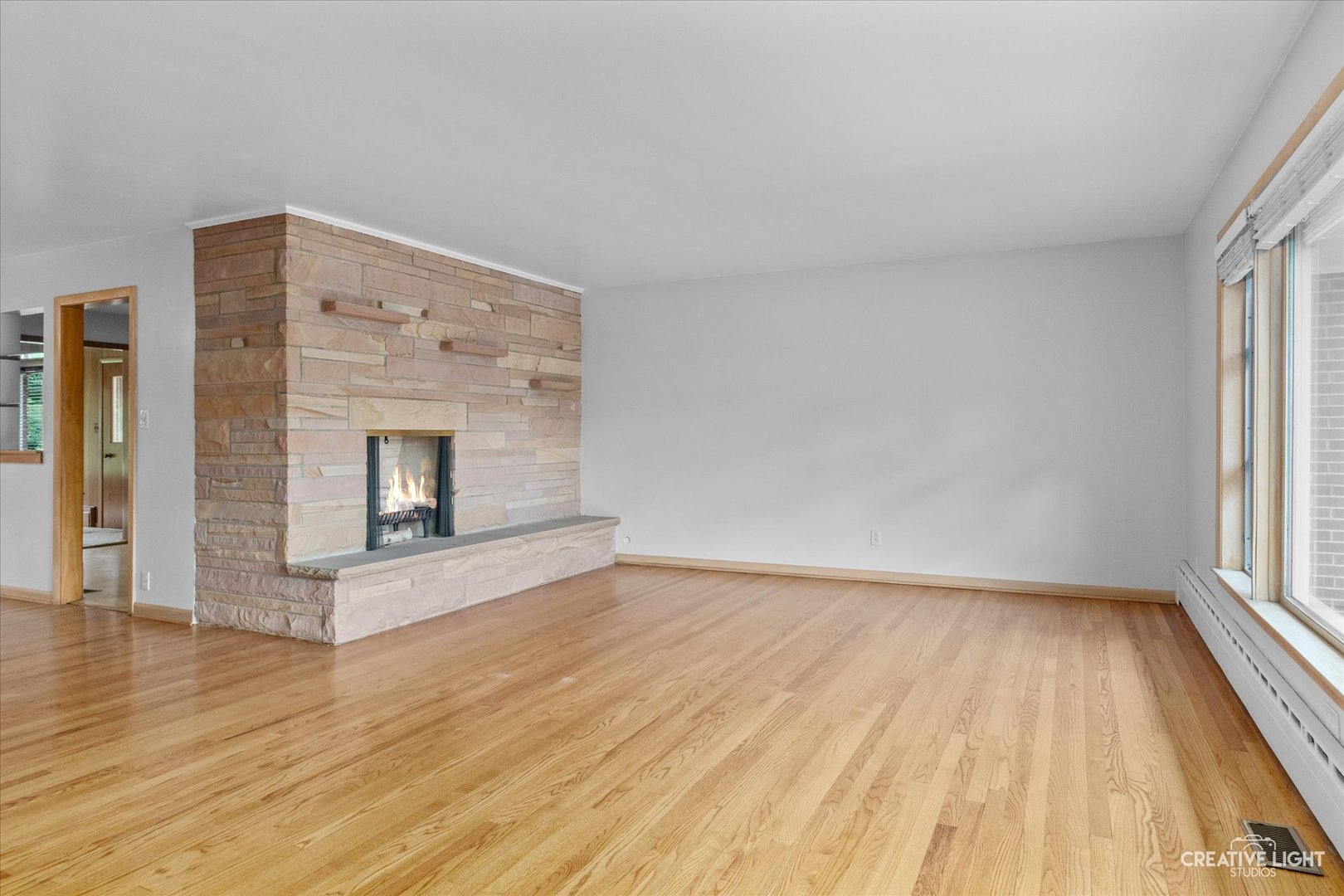 1402 Meadows Road Geneva, IL 60134 - Photo 4 of 30 a view of an empty room with wooden floor fireplace and a window