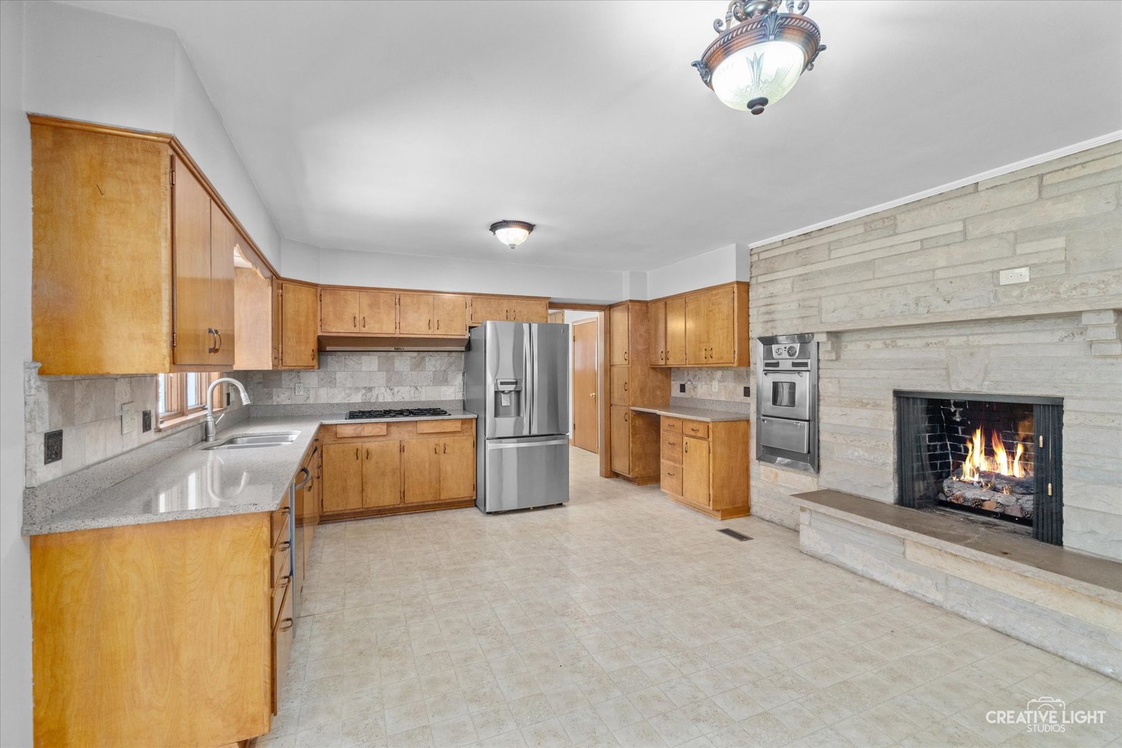1402 Meadows Road Geneva, IL 60134 - Photo 8 of 30 a large kitchen with a sink and a fireplace